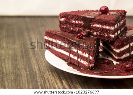 Cake with cranberries and cream, poured hot chocolate on a wooden background.
