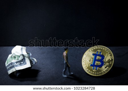 Cryptocurrency concept, man figure walks away from dollar banknote to golden bitcoin, changing from old currency to future currency, black background with copy space