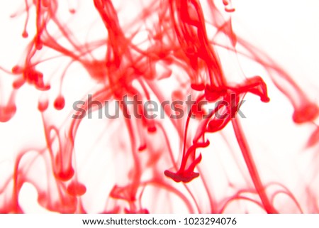 red liquid in water making abstract forms 