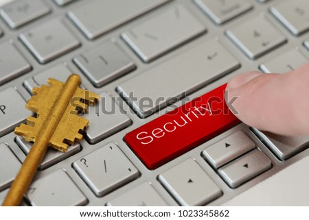 A finger press a red button with text Security on laptop keyboard.