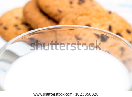 Close up of glass of milk on chocolate cookies background.