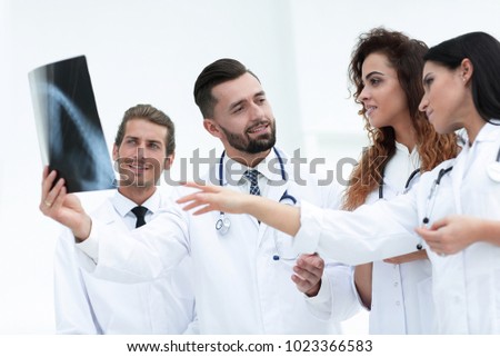 group of medical workers looking at patient's x-ray film