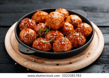 Chicken Meatballs with glaze on black wooden  background.  Royalty-Free Stock Photo #1023385783