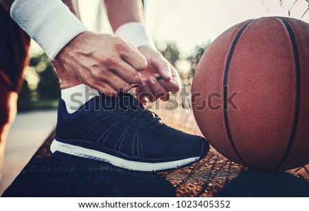 Basketball player tying sport shoes. Sport, recreation concept