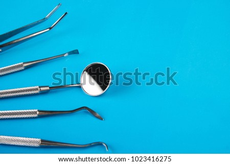 Set of Dentist's medical equipment tools. Stainless steel dental equipment on blue background with copy space.  Royalty-Free Stock Photo #1023416275