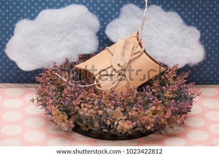 Beautiful photo of a gift box close-up, on a grass against clouds background