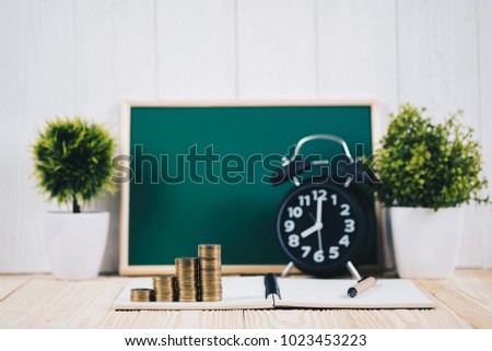 Step of coins stacks and alarm clock with green chalkboard, notebook and financial graph, business planning vision and finance analysis concept idea.