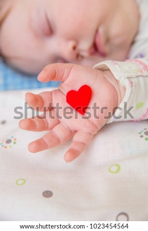 Baby  holding a heart.