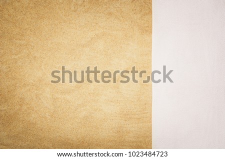Top view of sandy beach with towel frame. Background with copy space and visible sand texture. Border composition made of towel