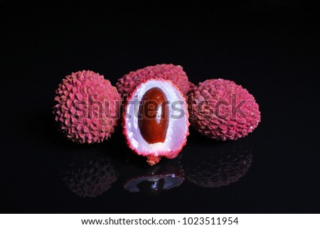 Lychee or litchi litchies or lychees on black reflective studio background. Isolated black shiny mirror mirrored background for every concept....