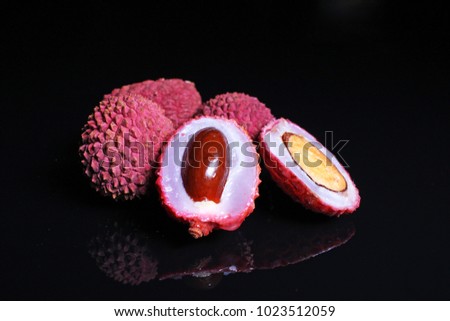 Lychee or litchi litchies or lychees on black reflective studio background. Isolated black shiny mirror mirrored background for every concept.