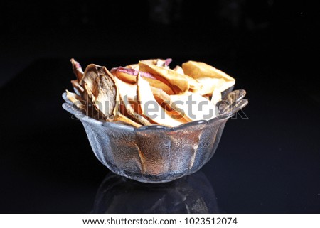 Apple chips on black reflective studio background. Isolated black shiny mirror mirrored background for every concept..