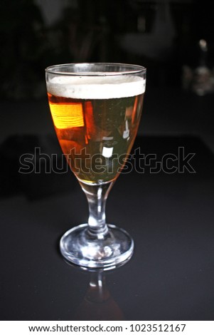 Beer on glass on black reflective studio background. Isolated black shiny mirror mirrored background for every concept..