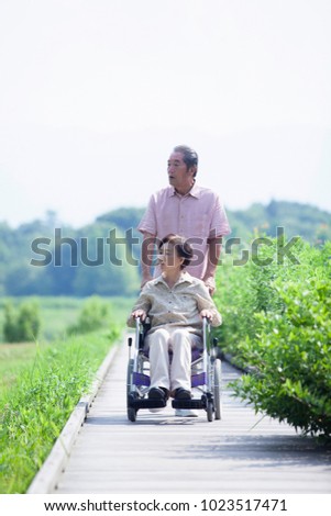 Elderly couple of the Japanese to take a walk in a wheelchair