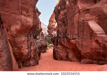 Red stone walls of the canyon of Wadi Rum desert in Jordan. Wadi Rum also known as The Valley of the Moon is a valley cut into the sandstone and granite rock in southern Jordan to the east of Aqaba. Royalty-Free Stock Photo #1023556555