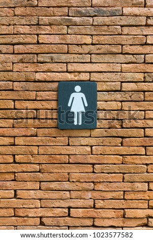 The restroom sign in the red brick wall background