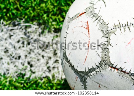 old soccer ball on green grass