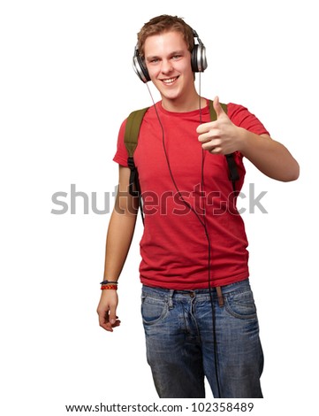 portrait of a cheerful young student listening to music and gesturing good with headphones over a white background