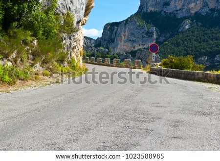 Mountain road between forests in Alpes-de-Haute-Provence department in southeastern France. Neighborhoods of a medieval city of Castellane and part of route Napoleon.