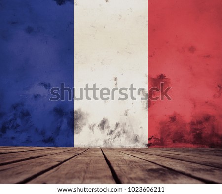 The floor of planks and plastered wall with a painted French flag.