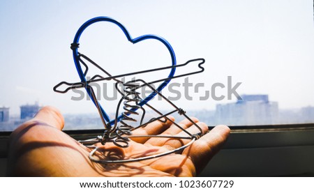 Heart-shaped coil, placed on the back hand, is sunlight.
Heart from the wire and the concept. Giving love