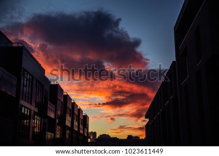 Dramatic Sunset Clouds over City in Sky with Silhouetted Buildings