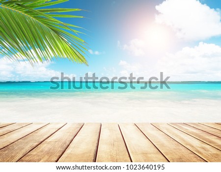 Blurred blue sky and sea with bokeh light and old wooden table background