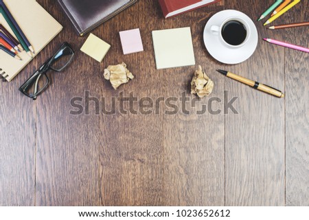 Top view of wooden desktop with coffee cup, stationery and other items. Copy space. Lifestyle and occupation concept 