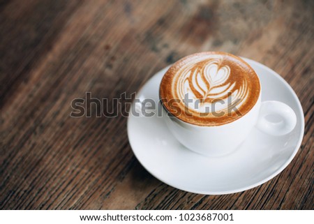 Cup of cappuccino with beautiful latte art on wooden table. Flat lay style. Royalty-Free Stock Photo #1023687001