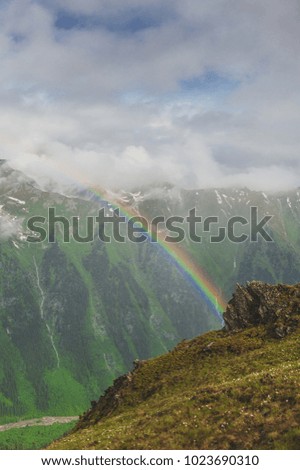 Beautiful mountain landscape with rainbow and blue sky