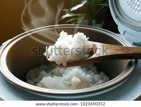 Jasmine rice cooking in electric rice cooker with steam. Soft Focus, Rustic tone picture. Royalty-Free Stock Photo #1023690352