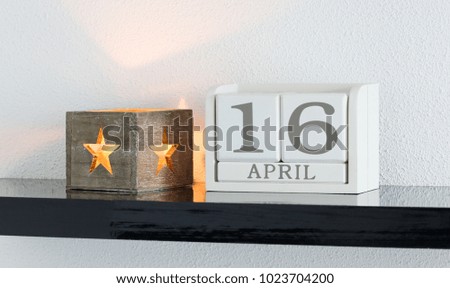 White block calendar present date 16 and month April on white wall background