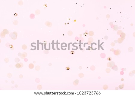 Golden decorations on pink pastel background. Top view. Festive greeting concept.