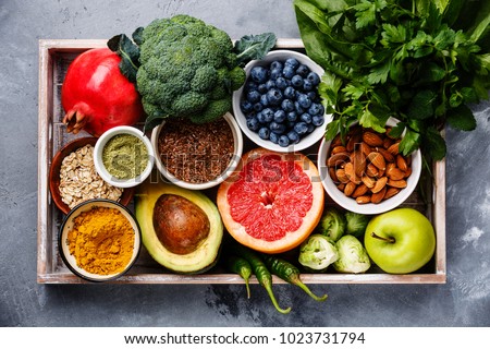 Healthy food clean eating selection in wooden box: fruit, vegetable, seeds, superfood, cereals, leaf vegetable on gray concrete background Royalty-Free Stock Photo #1023731794