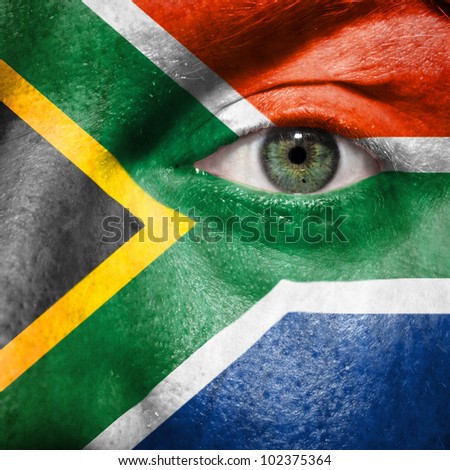 Flag painted on face with green eye to show South Africa support in sport matches