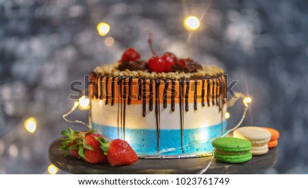 cake with cherry topping with strawberry and Macaron