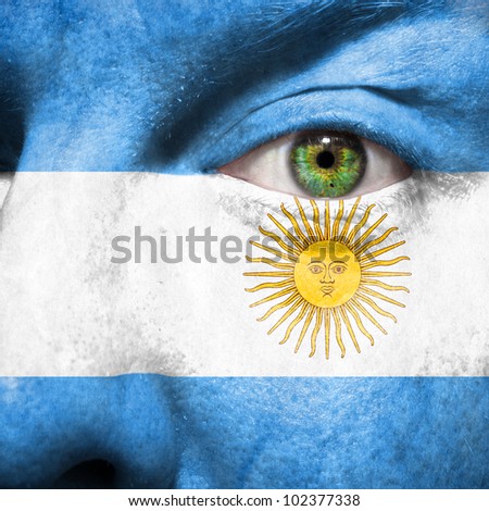 Flag painted on face with green eye to show argentina support