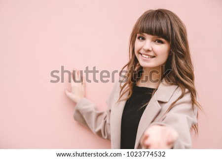 The happy woman stand on the pink wall background