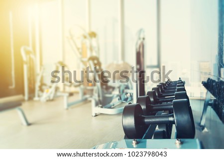 Fitness and healthy background concept. Dumbbells with blurred gym or sport club background at sunset. Picture for add text message. Backdrop for design art work.
