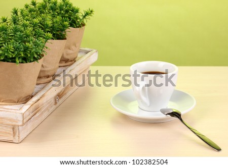 Coffee cup on table in cafe on green background