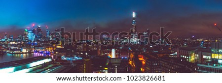 big panorama picture of london cityscape at night with thames river and shard