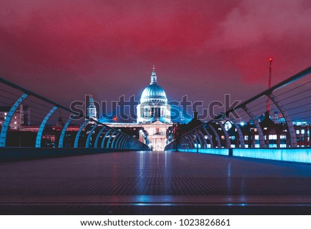 Millennium Bridge at night with st pauls at the end with colorful red night sky