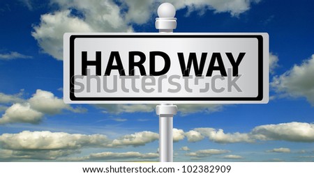 Hard way signpost on sky background