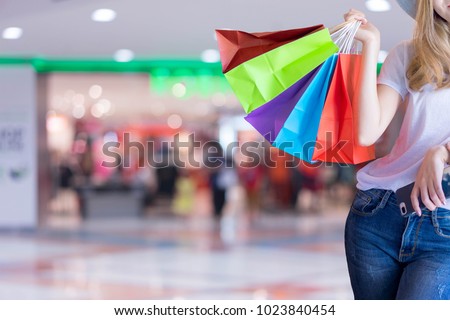 Asian woman shopping holding shopping bag and mobile phone at shopping center. Consumerism, sale and people online concept. Royalty-Free Stock Photo #1023840454