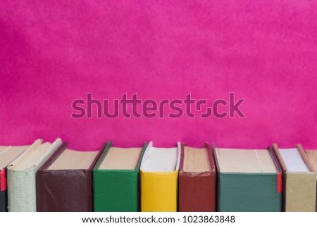 Books on a pink background. Female literature. Copy space
