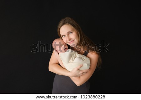 Happy mother with her newborn baby in her hands. Parenting concept.