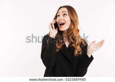 Adorable smiling woman with trendy hairstyle in black jacket talking on mobile phone and having pleasant conversation isolated over white background