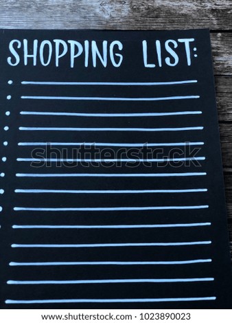 shopping list on black background with empty space. shopping list written with white chalk on a blackboard