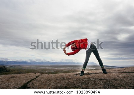 Young sportive woman makes morning yoga , Iceland