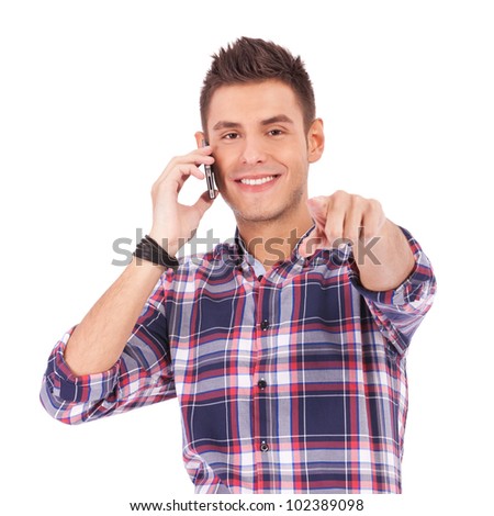 serious young man in casual clothes standing over white background with hands on hips